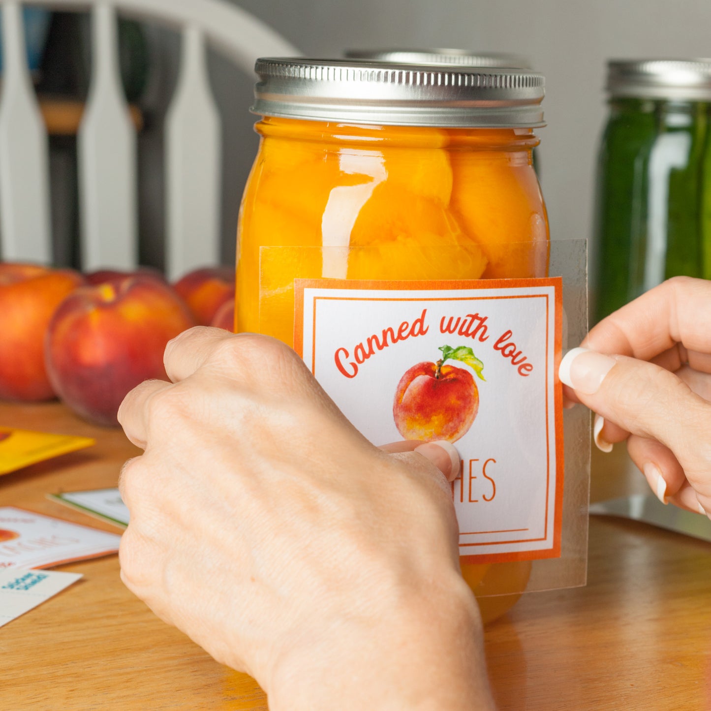 A woman's fingers shown applying a removable sticker to a glass jar.